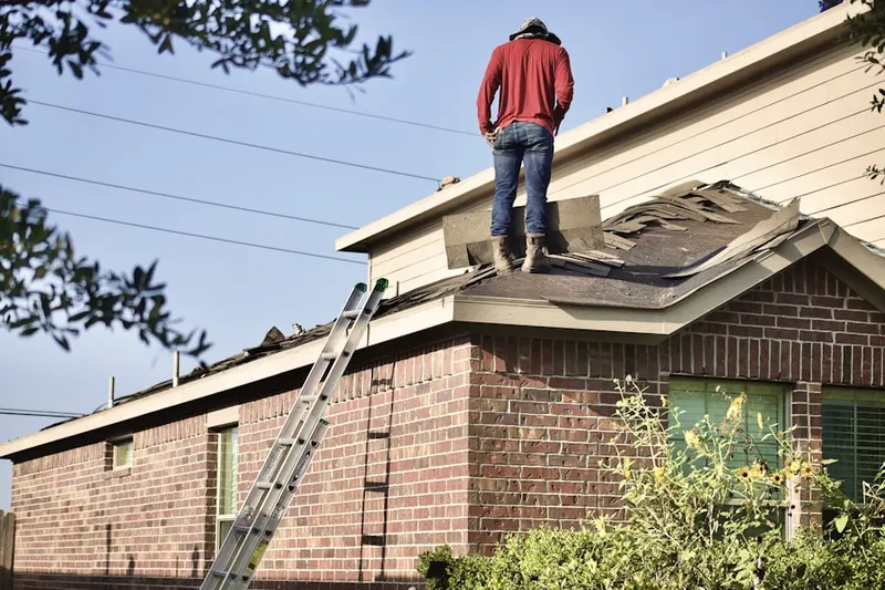 Professional roofer working on a residential roof in Comite de Families en Accion